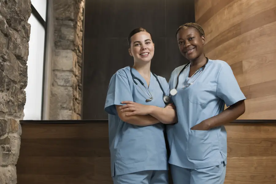 Two female nurses working at the clinic in scrubs<br />